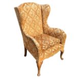 A Georgian style wing armchair with loose cushion and rounded arms above a sprung upholstered