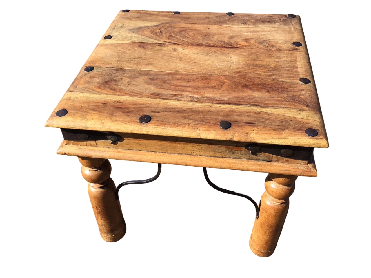 A square hardwood coffee table with hammered wrought iron nailed decoration above a frieze with