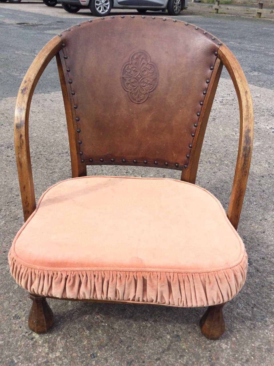 A 20s hardwood low armchair with studded embossed leather back and curved arms above a seat with - Image 2 of 3