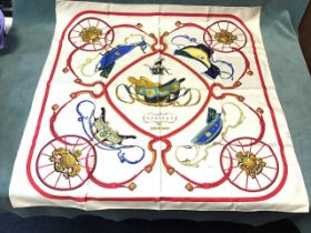 A Hermès silk scarf by Ledoux, titled Springs, depicting five carriages surrounded by frames with