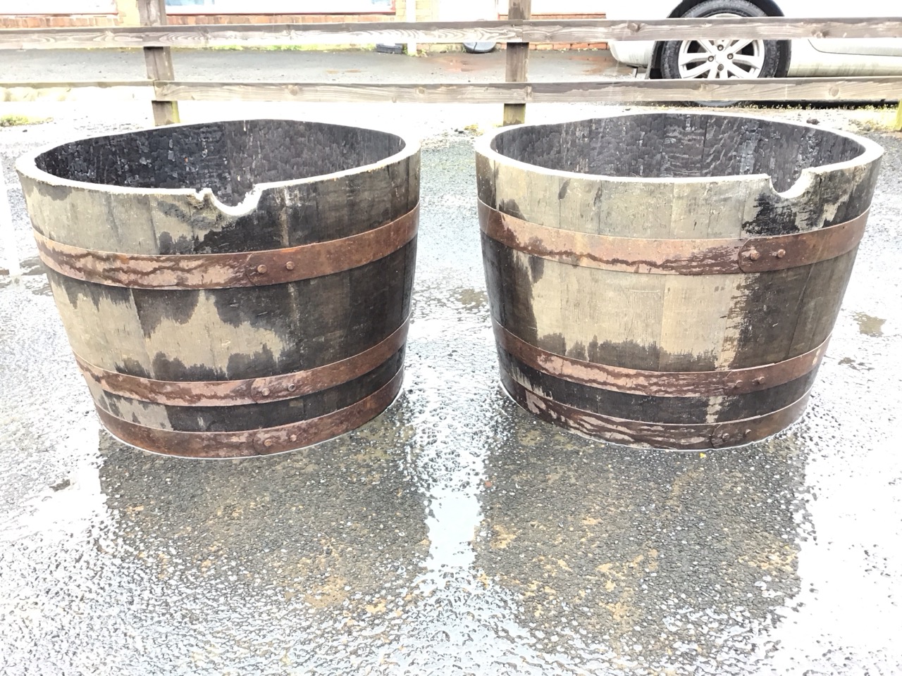 A pair of oak whisky barrel garden tubs, the staves bound by three riveted metal strap bands. (17. - Image 2 of 3