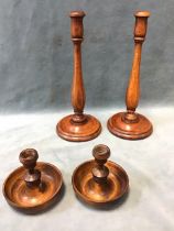 A pair of turned oak candlesticks with baluster columns on circular bases - 12.5in; and a turned