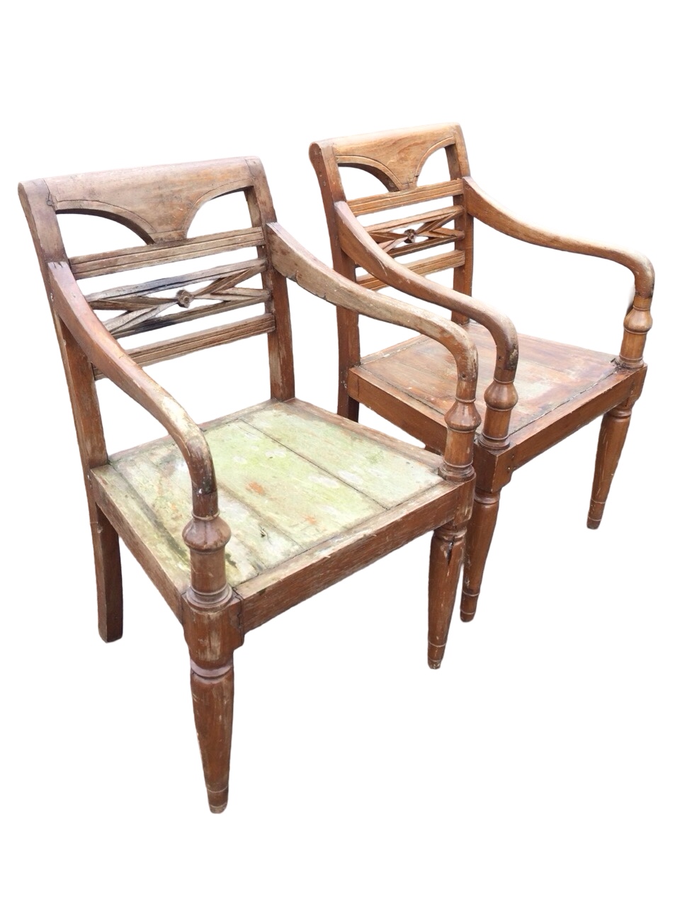 A pair of hardwood armchairs with shaped arms on columns, the backs with carved rails, the solid