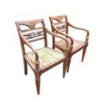 A pair of hardwood armchairs with shaped arms on columns, the backs with carved rails, the solid