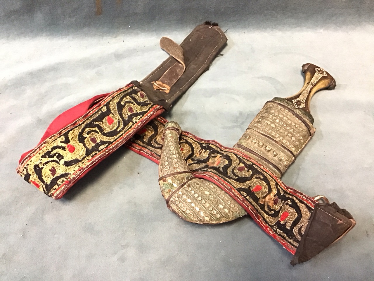 An Arabian curved jambiya with horn hilt, decorated with elaborate wirework repousse mounts to