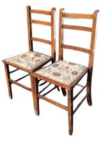 A pair of Edwardian oak ladderback chairs, the flared studded upholstered seats, raised on square