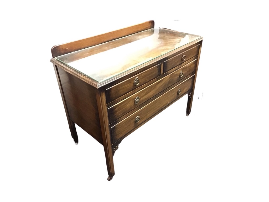 An Edwardian mahogany chest of drawers with raised back and moulded rectangular top with plate glass
