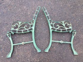 A pair of cast iron bench ends, the backs and seats pierced to take battens, with scrolled arms