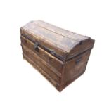 A domed top seamans chest with studded battens and iron mounts, having carriage handles to ends. (