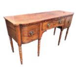 A regency mahogany sideboard with shaped rectangular rosewood crossbanded top above a cockbeaded