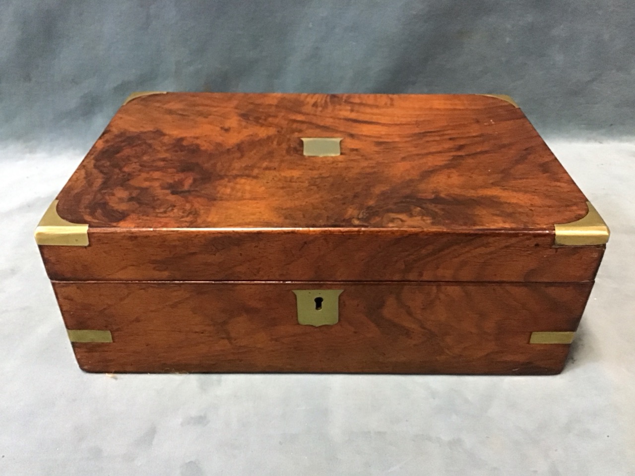 A Victorian brass bound walnut writing slope with brass shield plaque to top having interior with