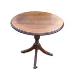 A Georgian style circular oak wine table with moulded top on a baluster turned column and