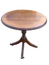 A Georgian style circular oak wine table with moulded top on a baluster turned column and