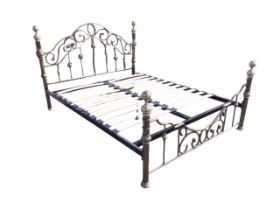 A Victorian style brushed brass double bed with arched scrolled headboard above spindles, the