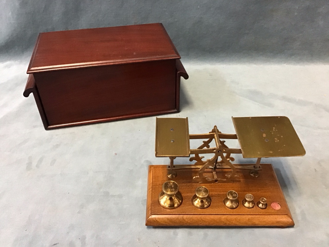 A Victorian set of brass postal scales in mahogany case with brass balance on pierced scrolled