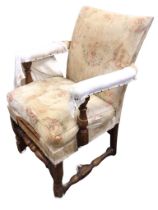 An Edwardian oak carolean style upholstered armchair, the seat with loose cushion flanked by