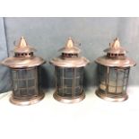 A set of three cylindrical steel & copper hanging candle lanterns with pagoda tops. (13.5in with