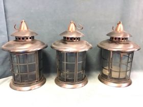 A set of three cylindrical steel & copper hanging candle lanterns with pagoda tops. (13.5in with