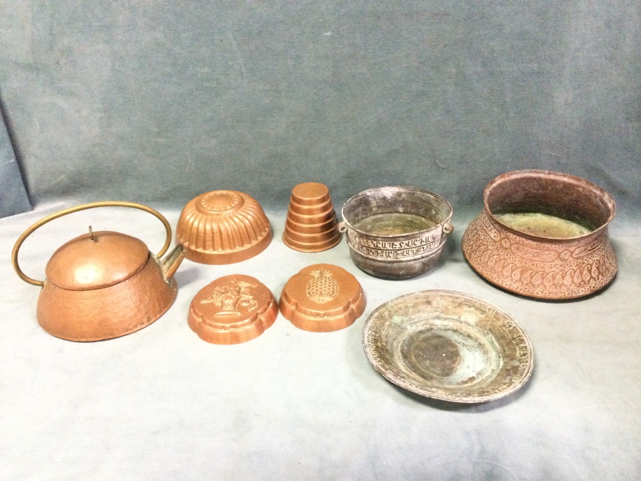 Three ancient Iranian copper vessels with Islamic decoration; four copper cooking moulds; and an