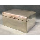 A rectangular silver cigarette box - London 1918, by FW Hentsch, the plain cover enclosing a cedar