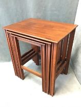 A mahogany nest of three tables with rectangular tops raised on grooved square legs joined by