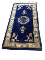 A Chinese wool carpet with central floral Shou medallion on a blue field with plantpots, braziers