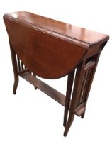 An Edwardian mahogany sutherland table with oval moulded top and two leaves supported on swing legs,