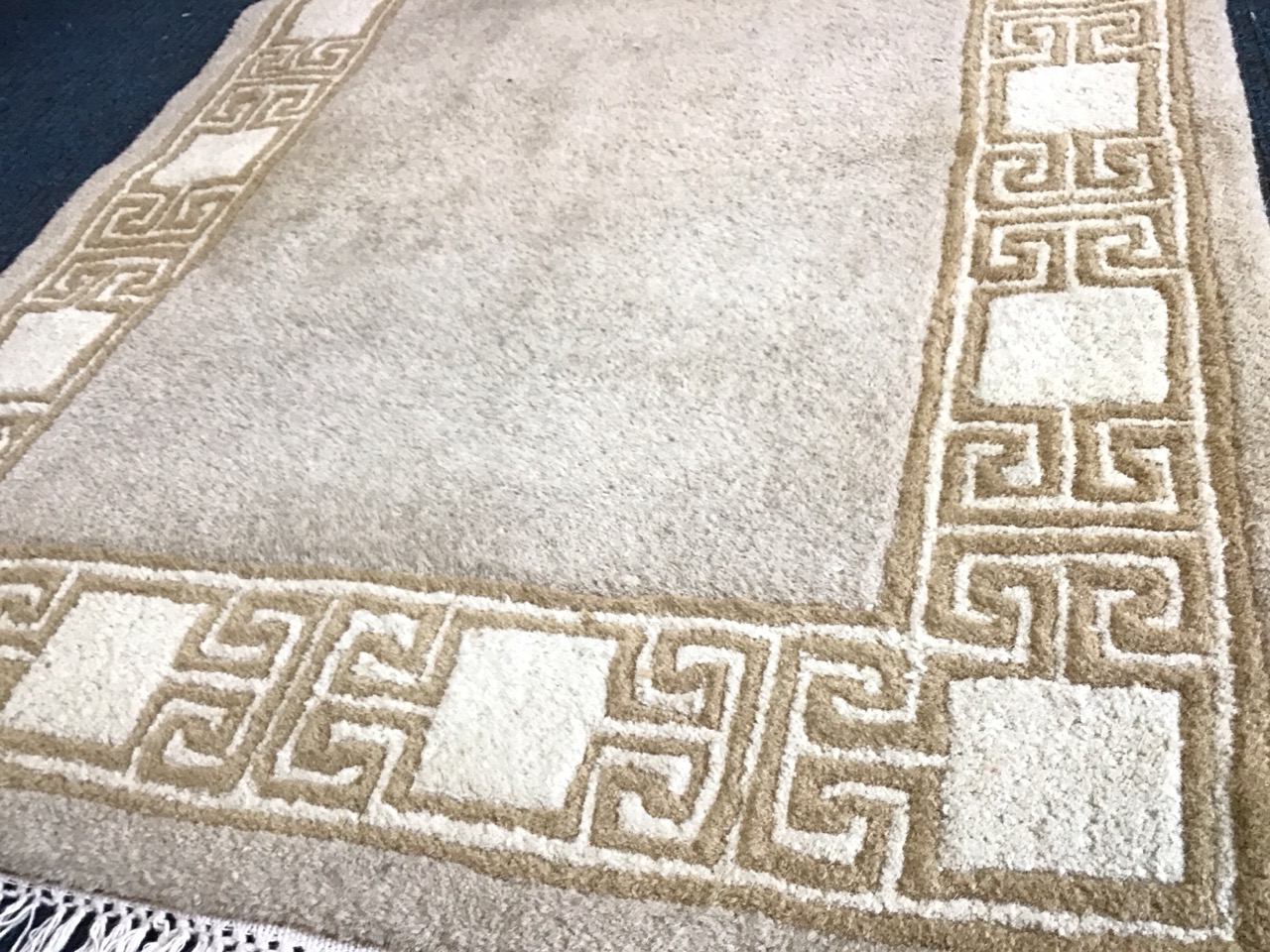 A Chinese wool rug with an ecru field within greek key and panel borders. (59.5in x 36in) - Image 2 of 3