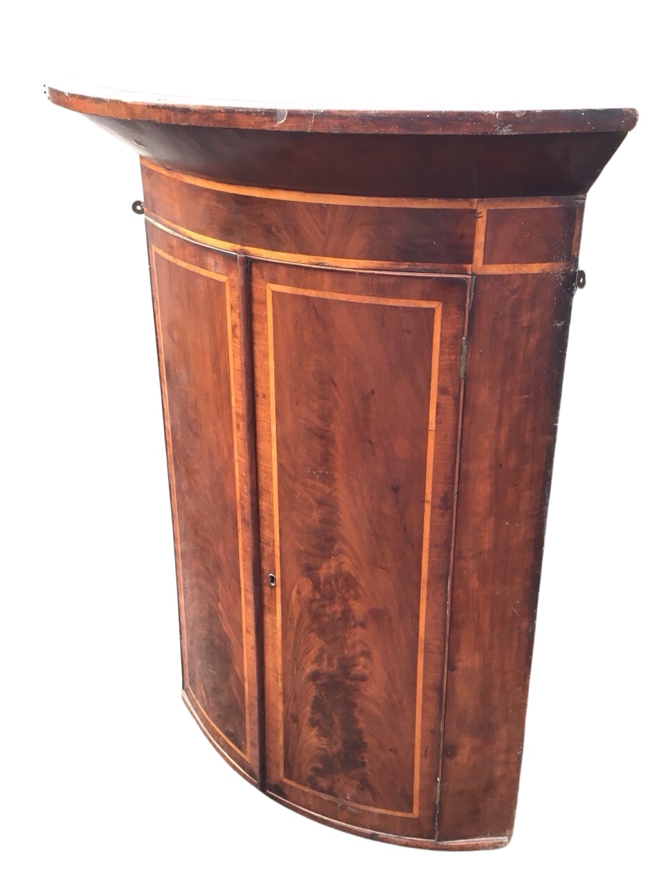 A C19th mahogany bowfronted hanging corner cabinet, the deep cornice and frieze above a pair of