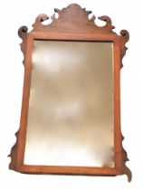 A Georgian style mahogany wall mirror, the fretwork scrolled crest above a rectangular plate in