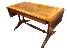 A regency style yew coffee table with satinwood crossbanded top and two leaves supported on