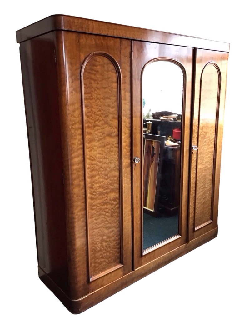 A Victorian mahogany wardrobe with plain cockbeaded cornice above a central arched mirrored door