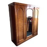 A Victorian mahogany wardrobe with plain cockbeaded cornice above a central arched mirrored door