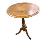 A circular nineteenth century mahogany occasional table with moulded top on vase shaped turned
