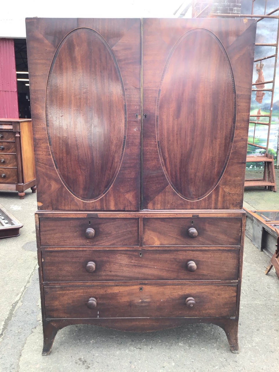 A Georgian mahogany press, the doors with crossbanded oval panels enclosing sliding shelves, above - Image 2 of 3