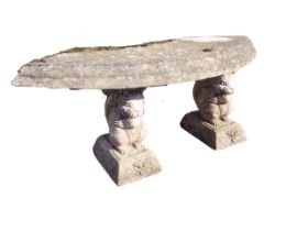 A crescent shaped composition stone garden bench with moulded slab seat raised on seated squirrel