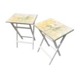 A pair of painted folding occasional tables, the rectangular tops decorated with floral prints,