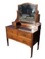 An Edwardian chequer strung mahogany dressing table, the arched bevelled mirror on shaped supports