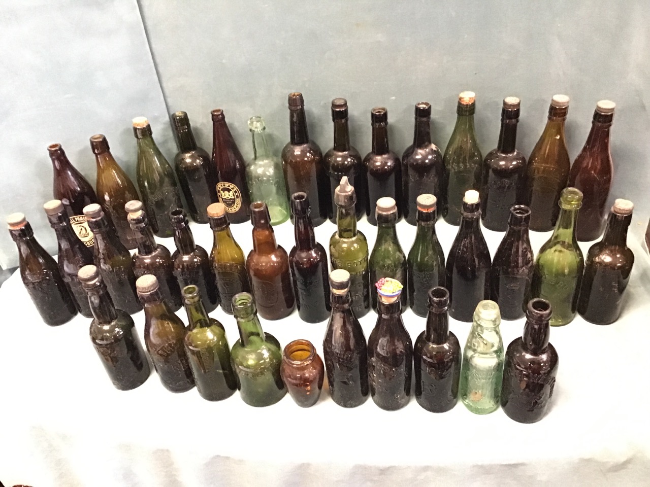 A collection of thirty-nine moulded brewery bottles mainly North Eastern, some with stoppers - Vaux,