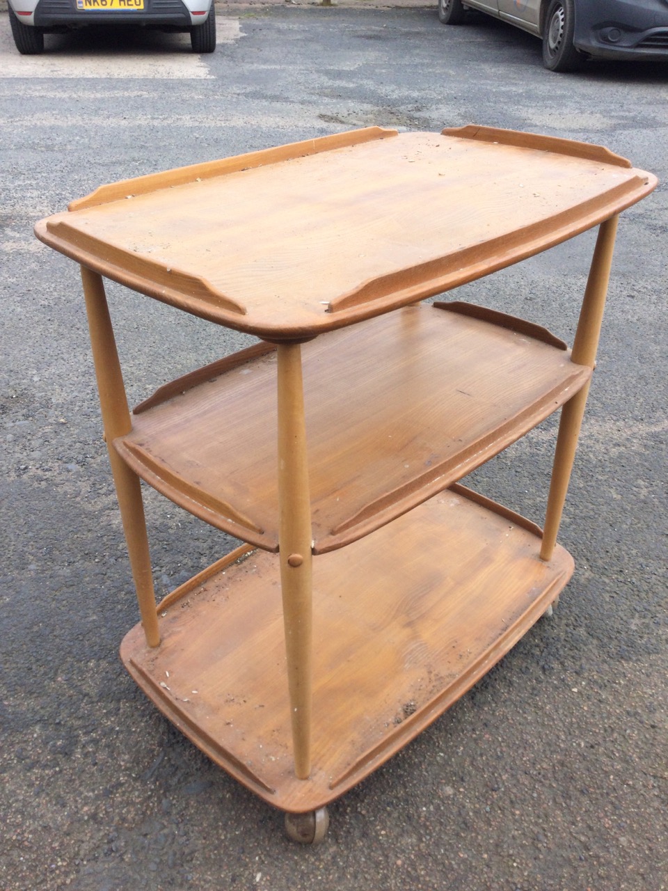 An Ercol elm three-tier trolley with rounded rectangular shelves on spindle supports with - Image 2 of 3