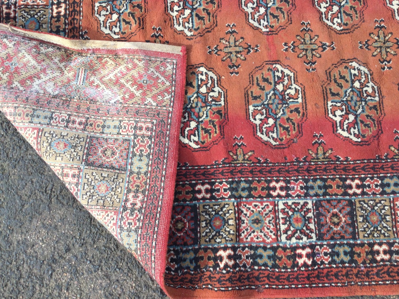 A Tekke style oriental rug woven with grid of oval floral medallions on red ground, framed by border - Image 3 of 3