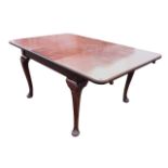 An Edwardian mahogany Ee-zi-way extending dining table with moulded rounded rectangular top having