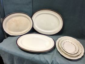 A set of three oval Adams ironstone graduated meat dishes with floral swag borders; a Booths ashet