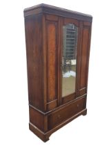 An Edwardian mahogany wardrobe with moulded blind fretwork frieze above a central bevelled