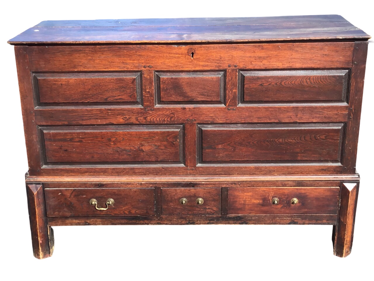 A C18th oak mule chest with rectangular top with fielded panelled front above three drawers