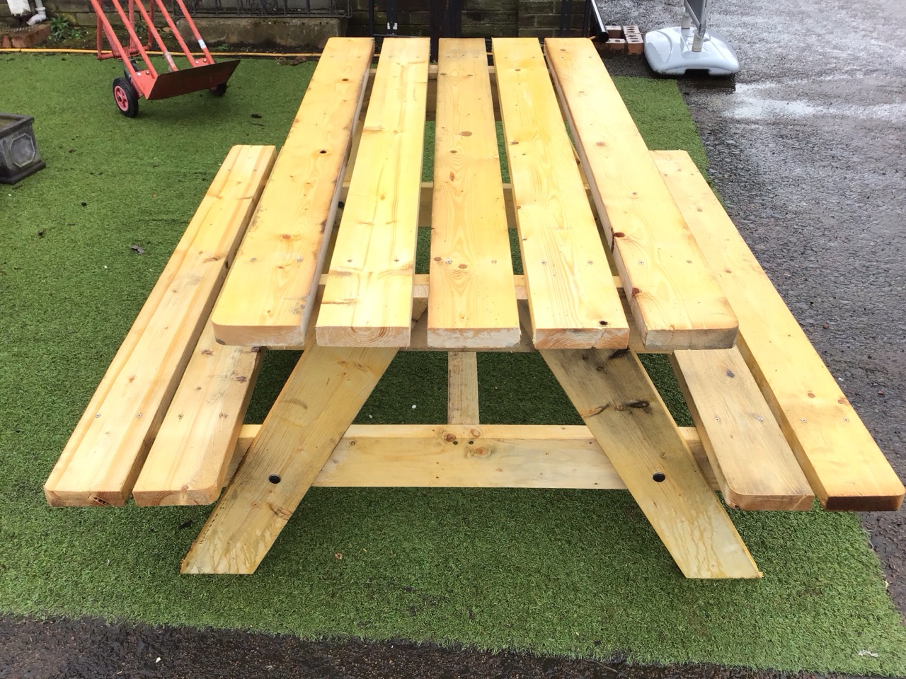 A garden bench table with rectangular plank top on angled supports flanked by integral batten seats. - Image 2 of 3