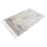 A rectangular Chinese wool aubusson style rug with central floral spray on an ivory ground, within