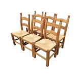 A set of six beech ladderback chairs with rush seats raised on column legs joined by rectangular