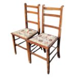 A pair of Edwardian oak ladderback chairs, the flared studded upholstered seats, raised on square