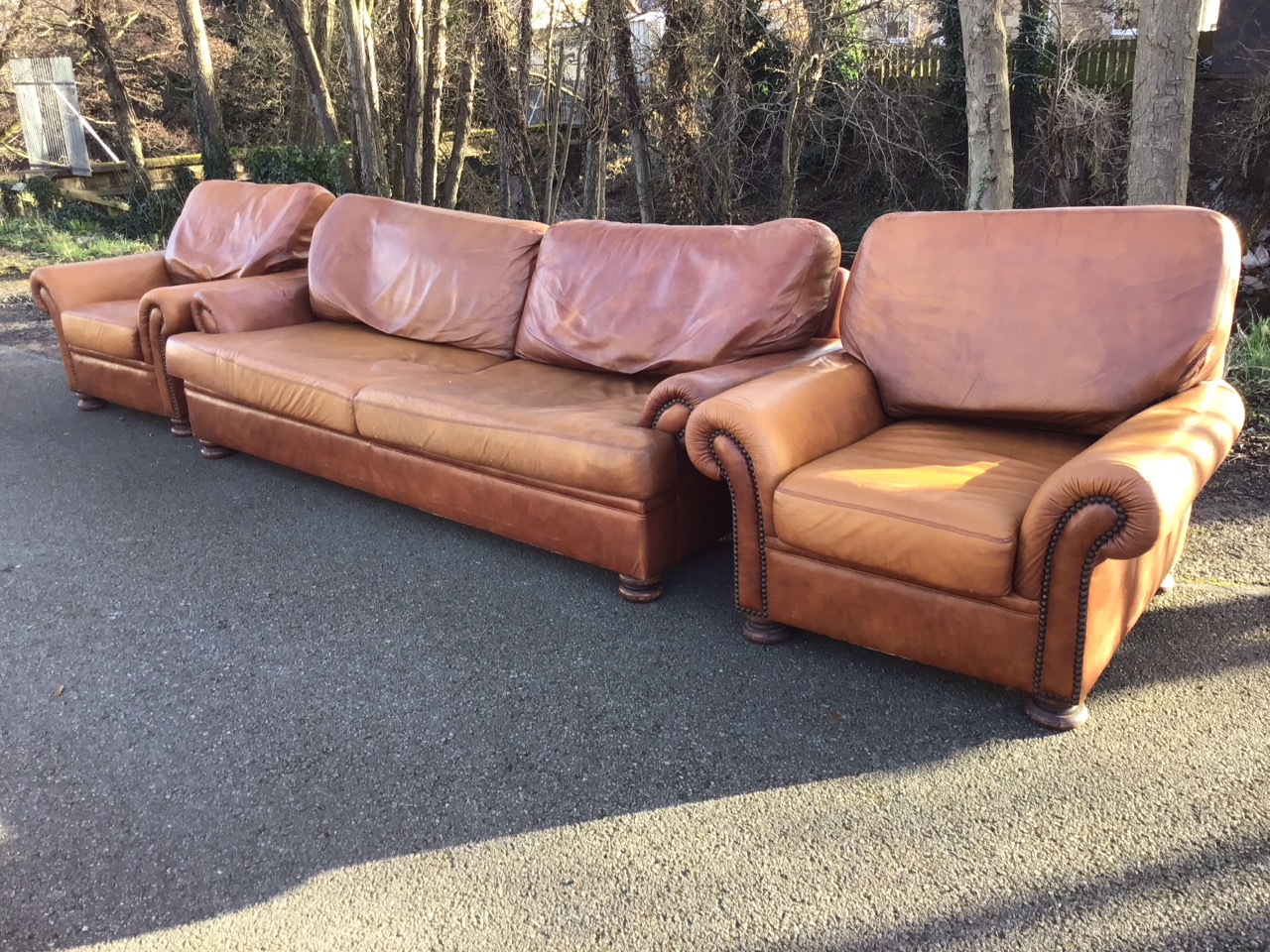 A leather three-piece suite with deep cushions and outscrolled arms with brass studding, the - Image 2 of 3